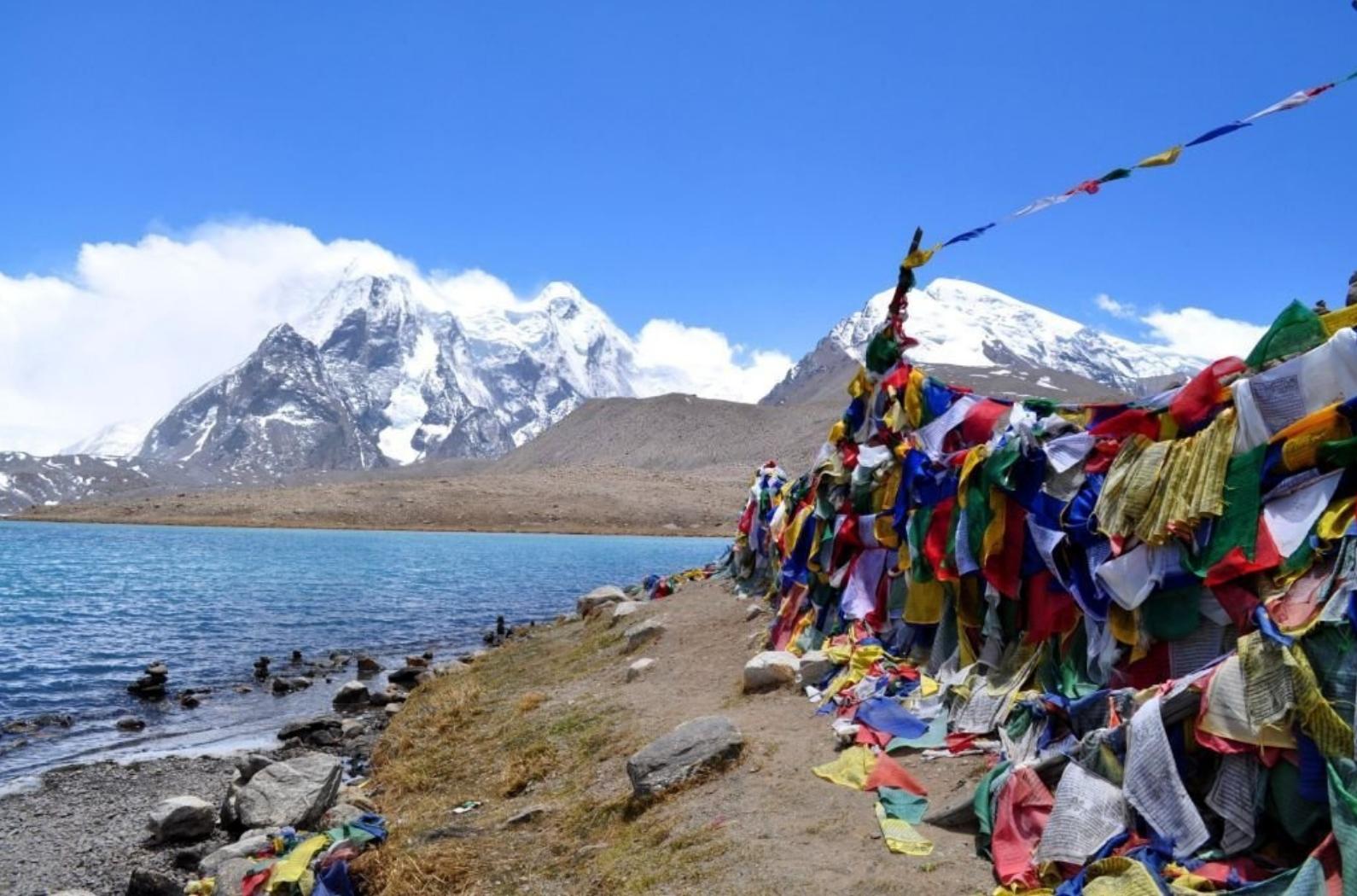 Buddhist prayer flags add color to the scenic landscape of Gurudongmar lake in Lachen.
