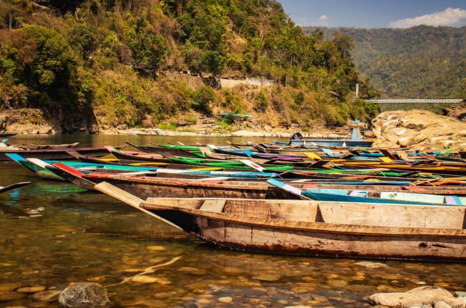 Colorful tourist traditional wood boats isolated many at river edge image is taken at dwaki lake Meghalya, India.