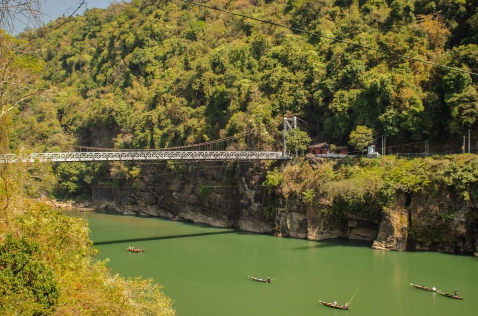 Iron cable bridge on lake surrendered with mountain forest and blue sky image is taken at Dwaki lake Meghalaya India. This bridge is connecting India and Bangladesh.