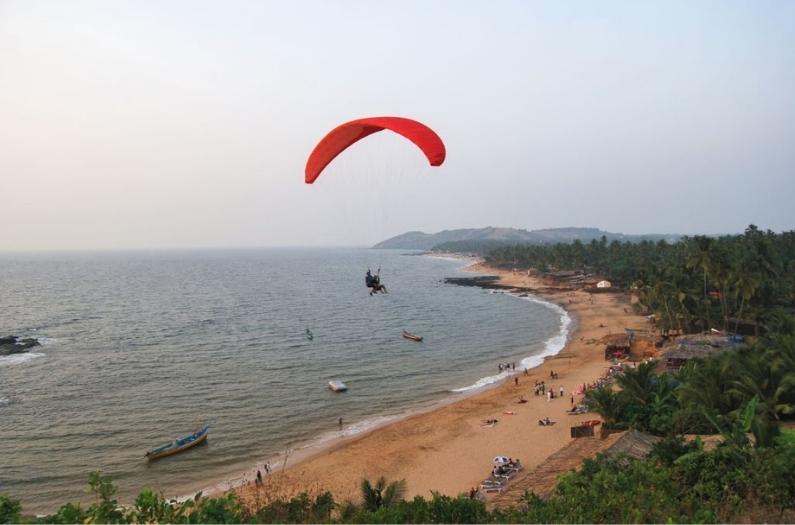 Tourist perform Paragliding activity in Vagator Beach.