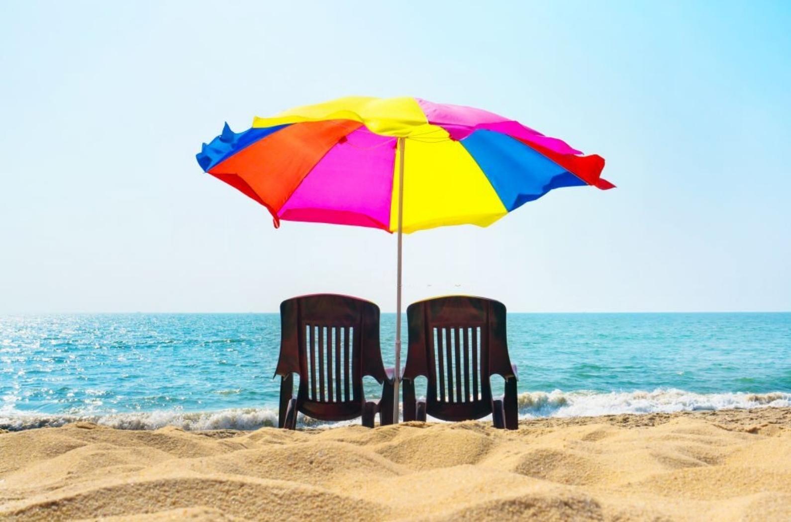Two lounge chairs under an umbrella on the Marari beach.
