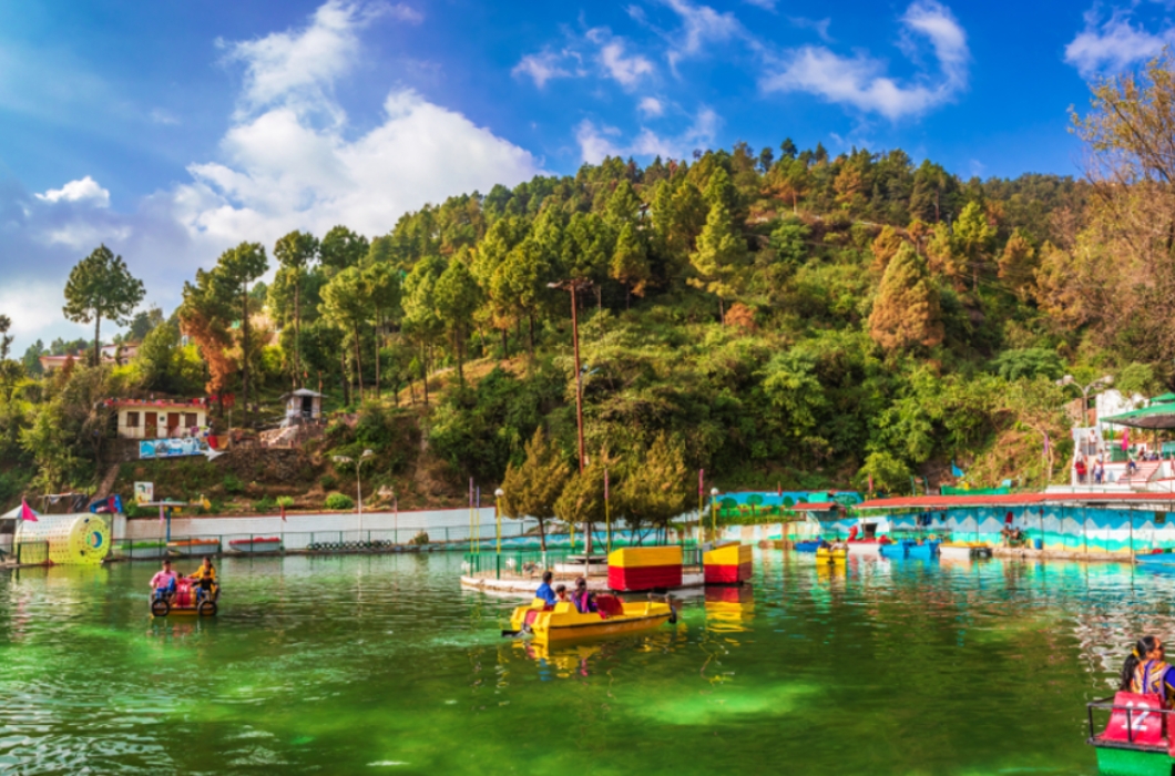 Scenic beauty of Lake surrounded by mountains and trees, people enjoying boating in the lake situated in Doon valley.