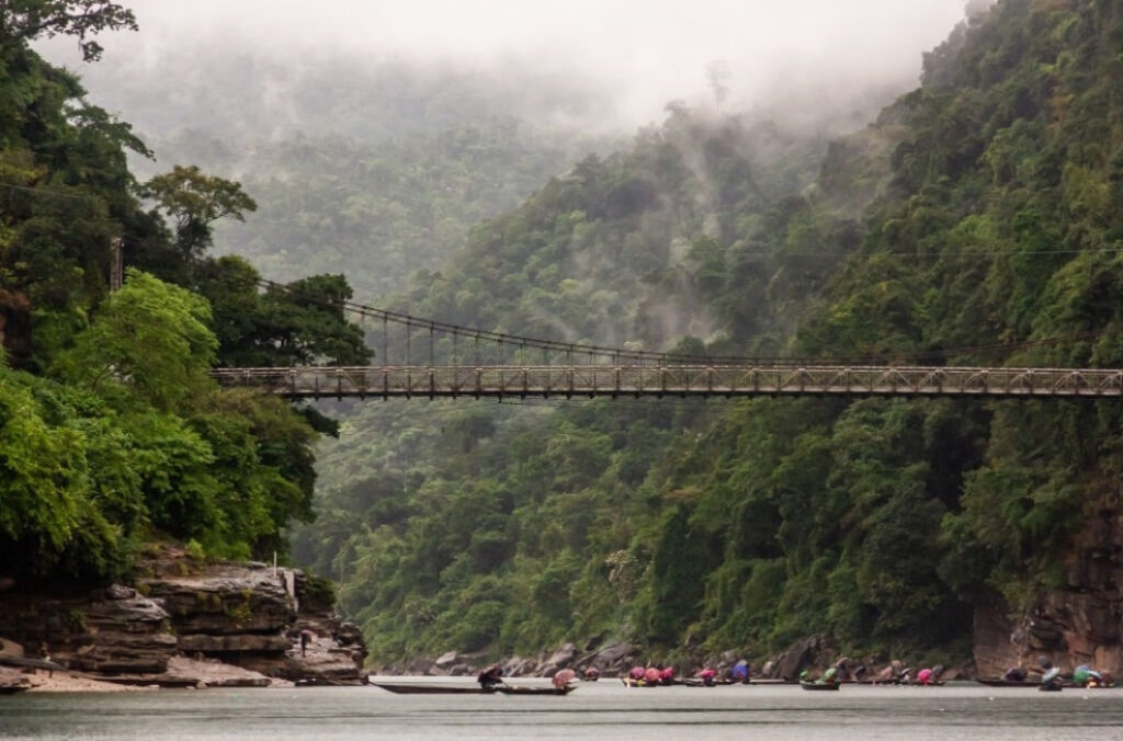 The old suspension bridge across the river in the forested hills of the village of Dawki.