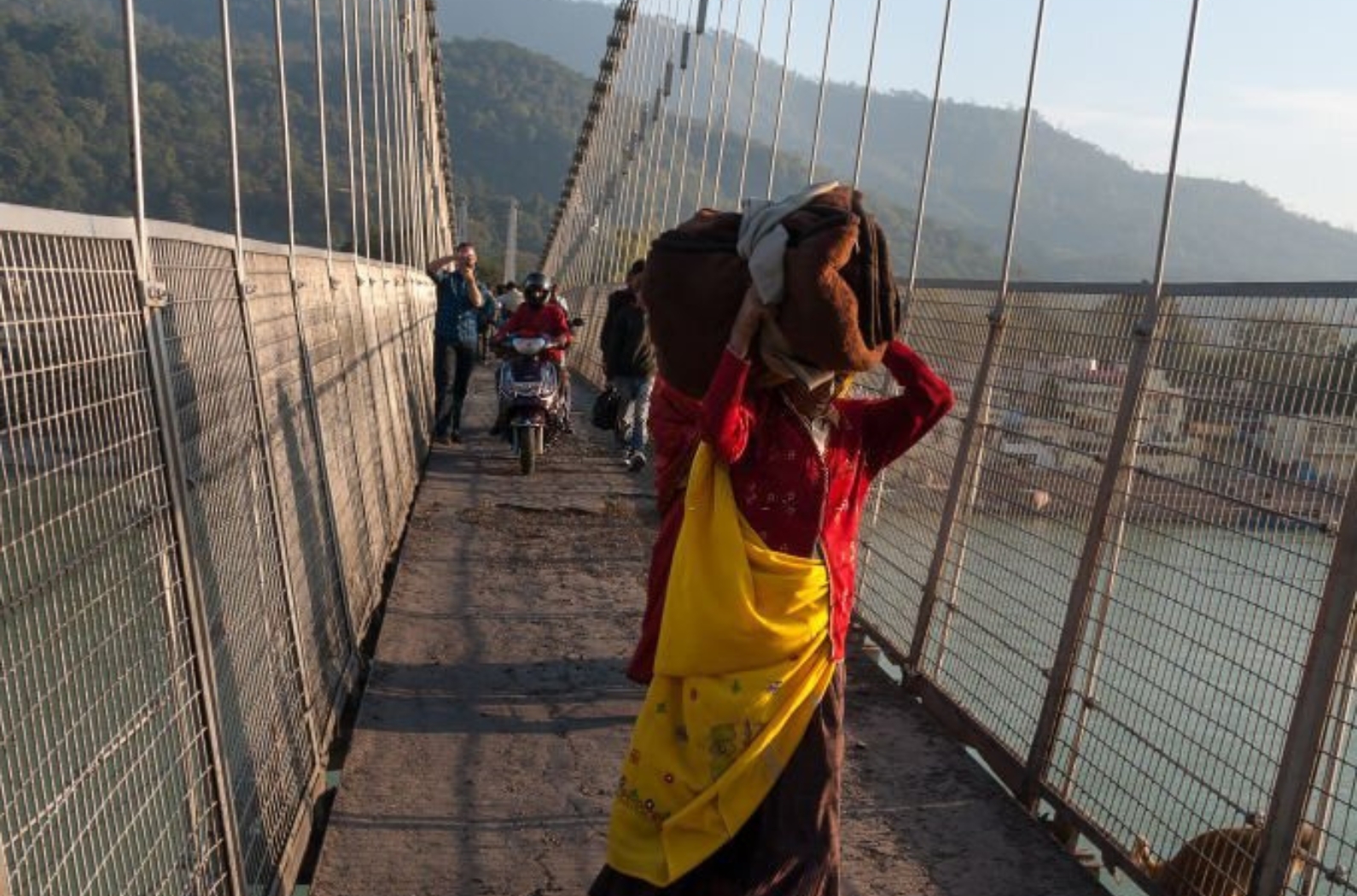 Unidentified Indian woman with big package on Ram Jhula bridge.