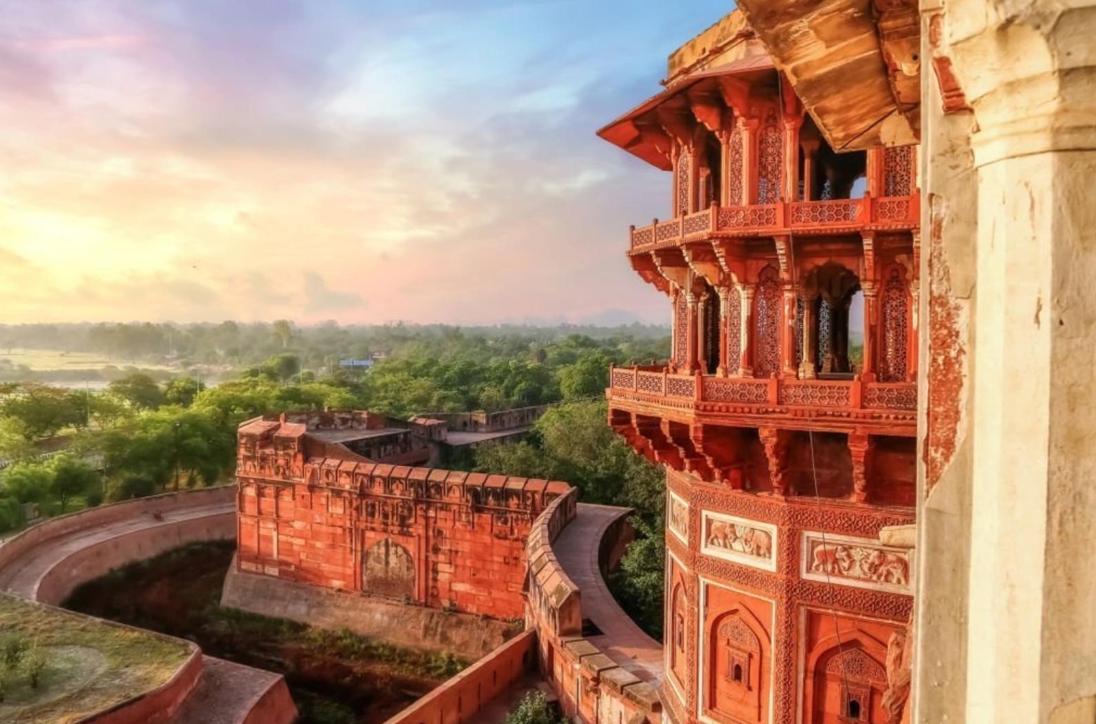 Famous medieval historic fort exterior structure with view of Agra city landscape at sunrise.