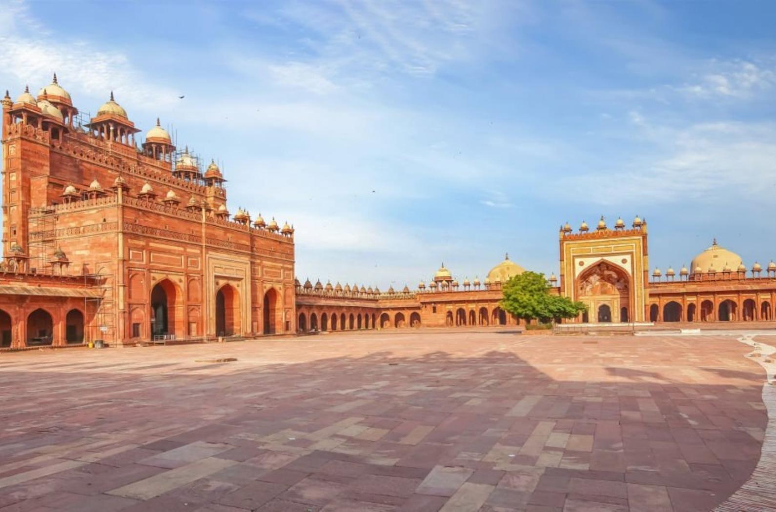 Fatehpur Sikri Agra courtyard with view of giant red sandstone gateway known as Buland Darwaza built by Mughal Emperor Akbar.