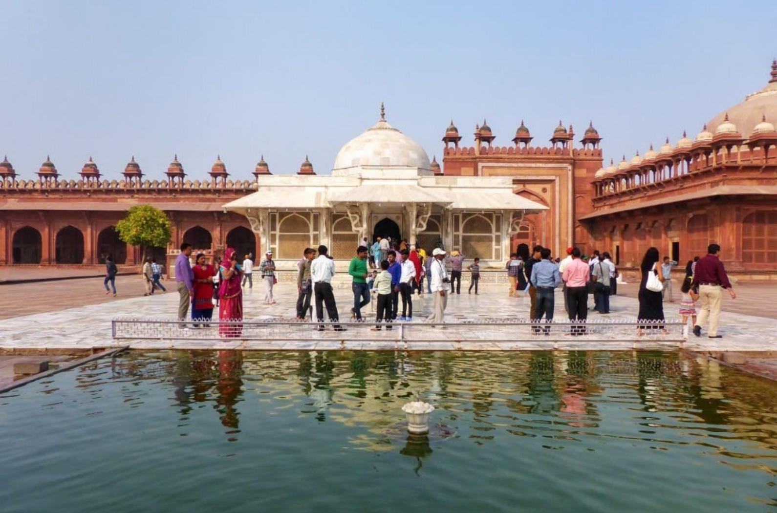 People standing in front of Tomb of Salim Chishti in the courtyard of Jama Masjid, Fatehpur Sikri, India. The tomb is famed as one of the finest examples of Mughal architecture in India.