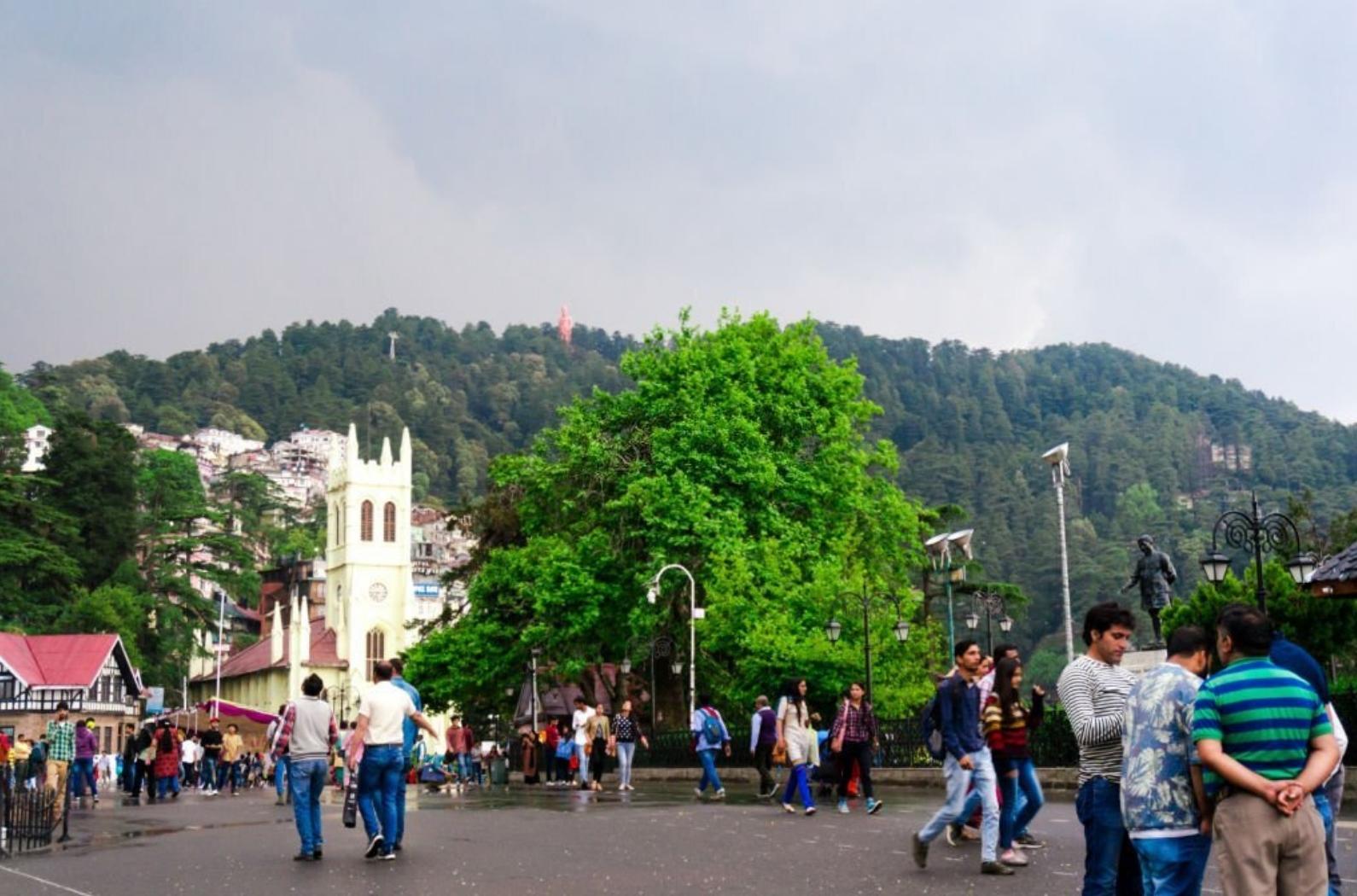People roaming around on the ridge in shimla with the christ church in the background.
