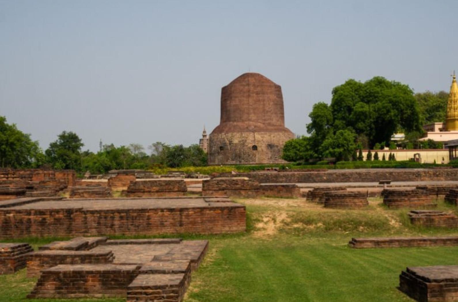 Ruins at the archaeological site of Sarnath, with Dhamek Stupa in the background. Sarnath, India