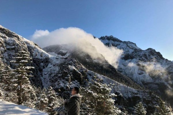 A lone bird watcher on bomdila seeks out the rare species on the mountains on a bright clear cold morning.