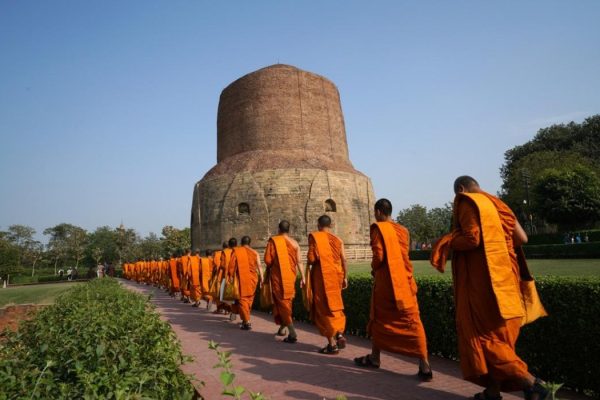 Buddhist monks walking candlelit Or publish dharma at Dhamek Stupa at Sarnath near Varanasi.