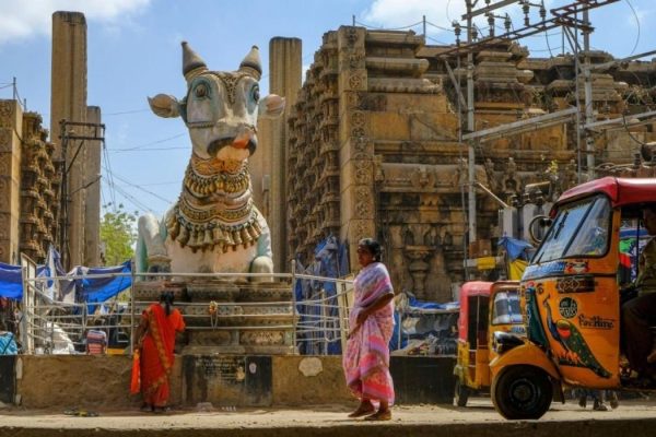 People walking around the blue Nandi in front of the entrance of the Pudhu Mandapa, Madurai, India